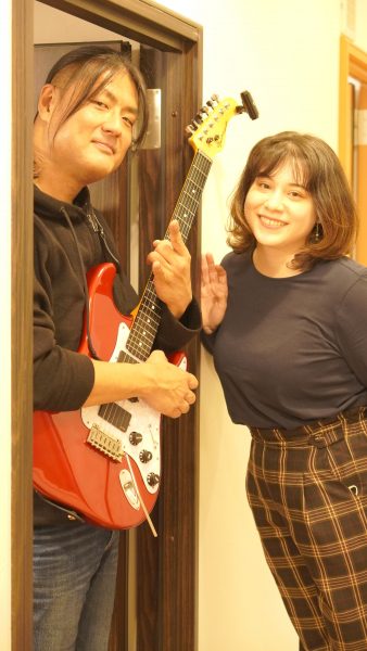 ギターを持ったギターの田村太一先生と再会する音楽教室スタッフきゃな